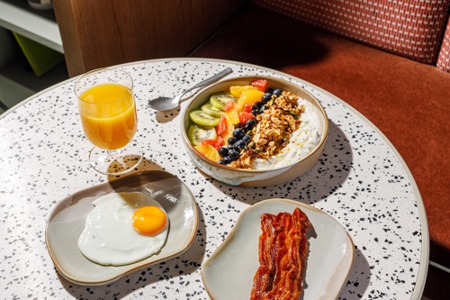 Breakfast bowls, friend egg and bacon on a table at Feels like June, Canary Wharf's new restaurant