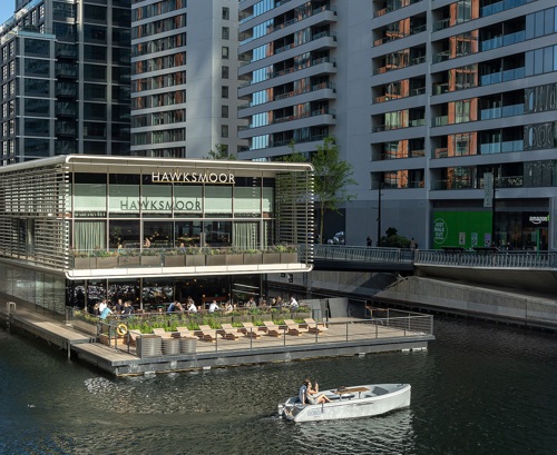 Boat passing on the water in front of Hawksmoor restaurant and bar